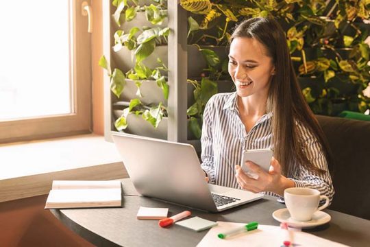 Young woman searching information in internet via laptop